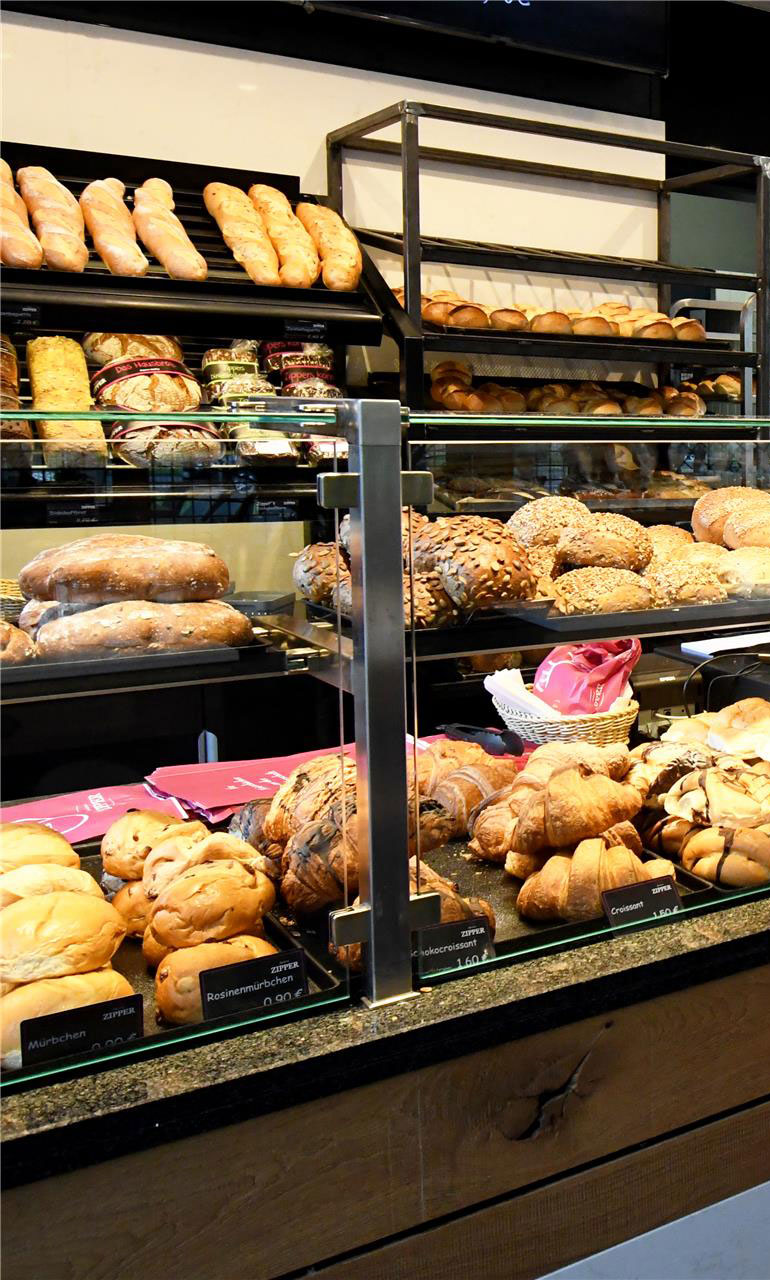 Die Gebäcke Auslage einer Zipper Filiale mit Mürbchen, Croissants und versirdenen Brötchen.